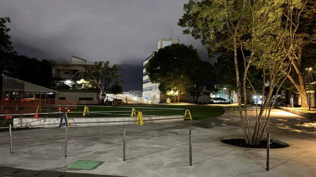 整備が進む中央公園の人工芝広場と新しいコンクリート舗装の夜景