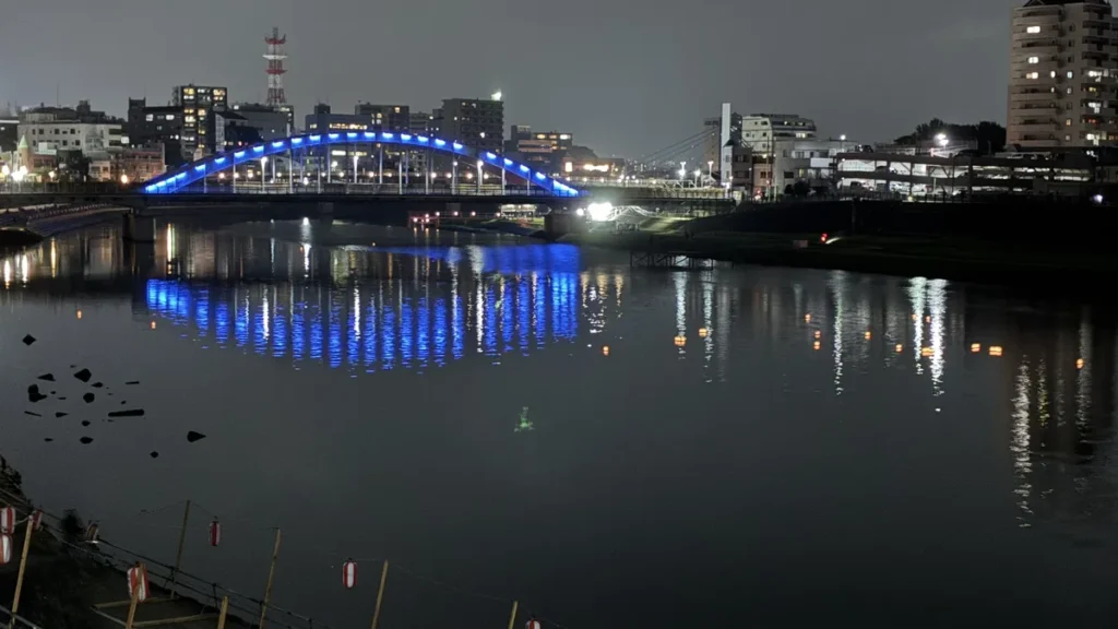 下流側から望む御成橋のブルーライトアップと沼津市街の夜景、右奥にあゆみ橋の主塔