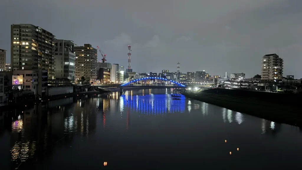 永代橋から上流を望む狩野川の夜景と、水面に浮かぶ灯ろう