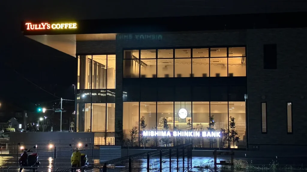 TULLY'S COFFEEとMISHIMA SHINKIN BANKの看板が並ぶ建物外観