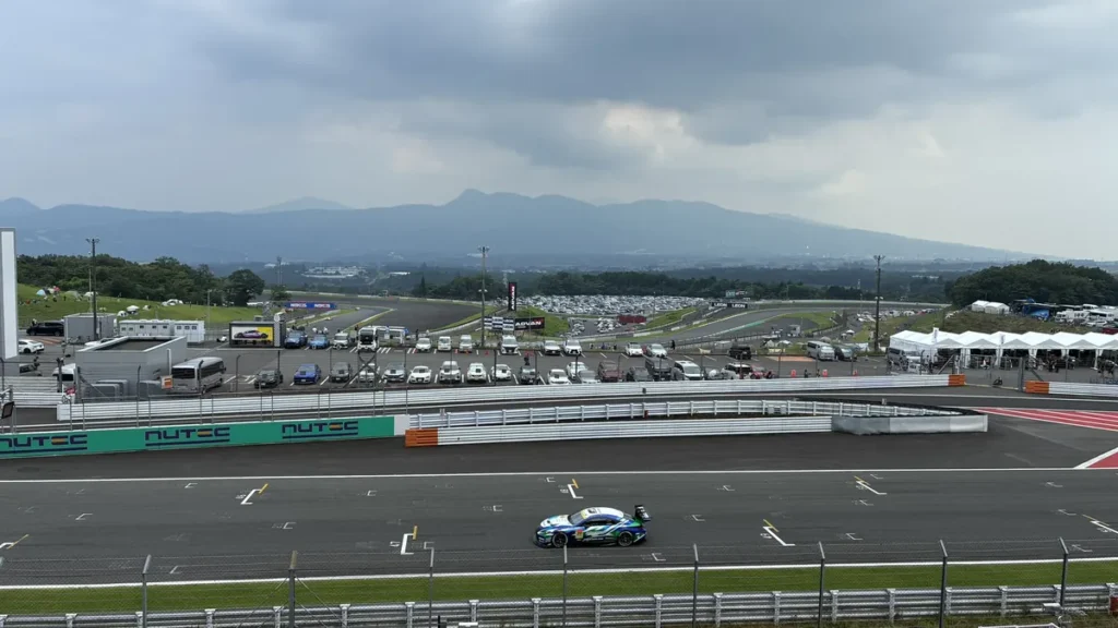 富士スピードウェイの最終コーナー立ち上がりを走るGT300マシン