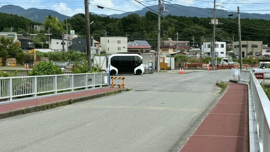 街の外周部に停車する自動運転車両と隣接する住宅地