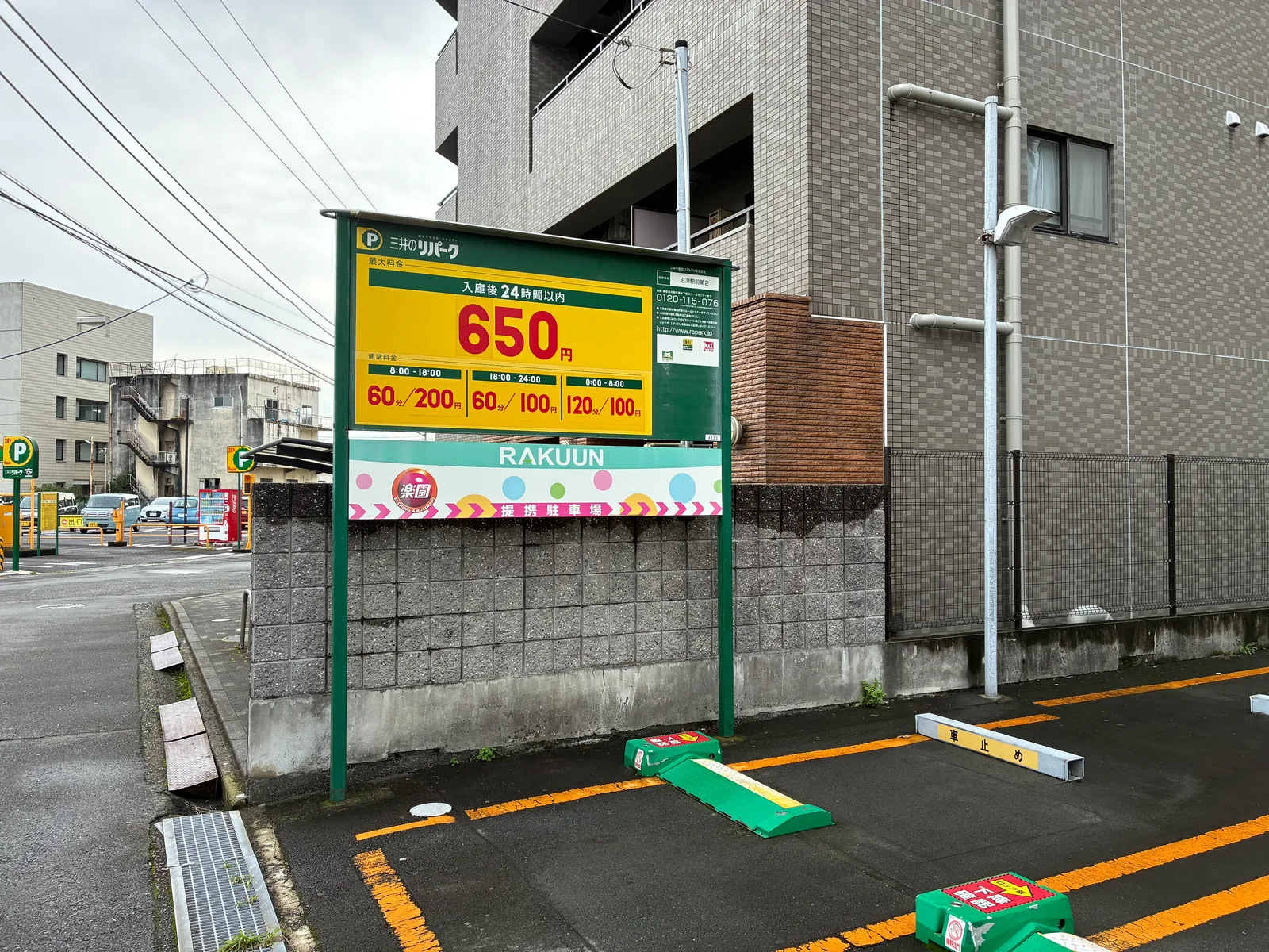 三井のリパーク沼津駅前第2の料金看板。入庫後24時間以内650円、8時から18時60分200円、18時から24時60分100円、0時から8時120分100円。下に楽園の提携駐車場の看板