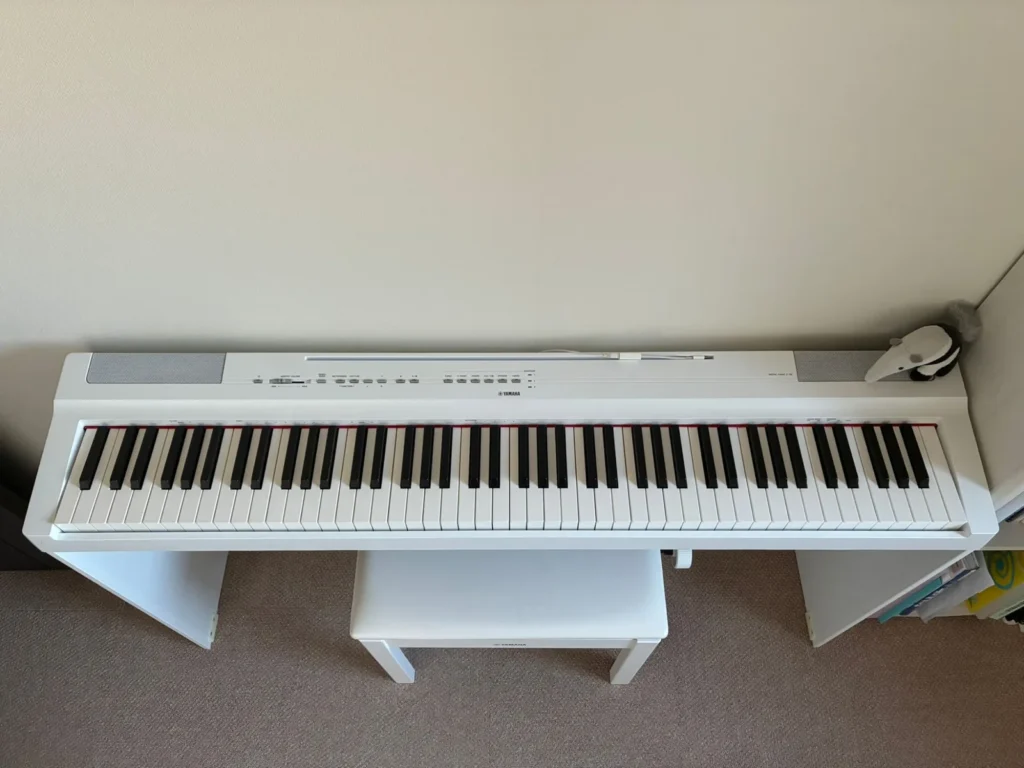 上から見た白いYAMAHA P-125。88鍵の鍵盤と、左右のスピーカーの間に並ぶ操作ボタン